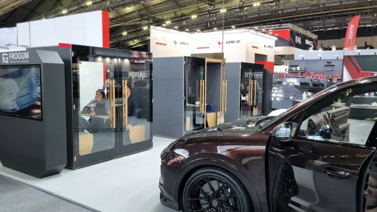 HIDE H4 acoustic booth at the FroGum stand at the Automechanika trade fair, with a car nearby