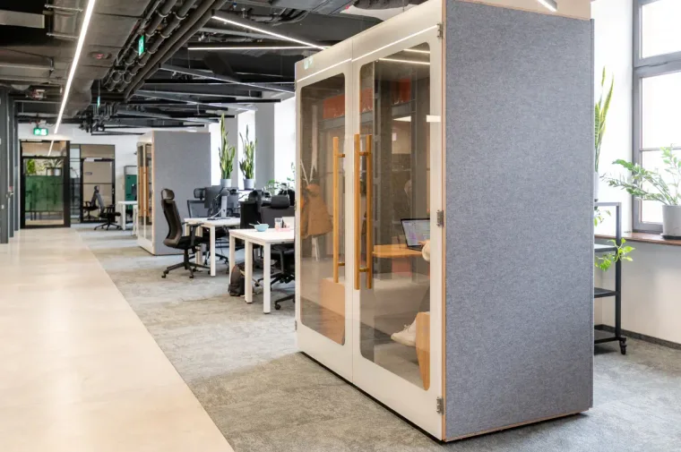 HIDE H2 acoustic booth in an open-plan office with exposed ceiling, another booth and desks visible behind