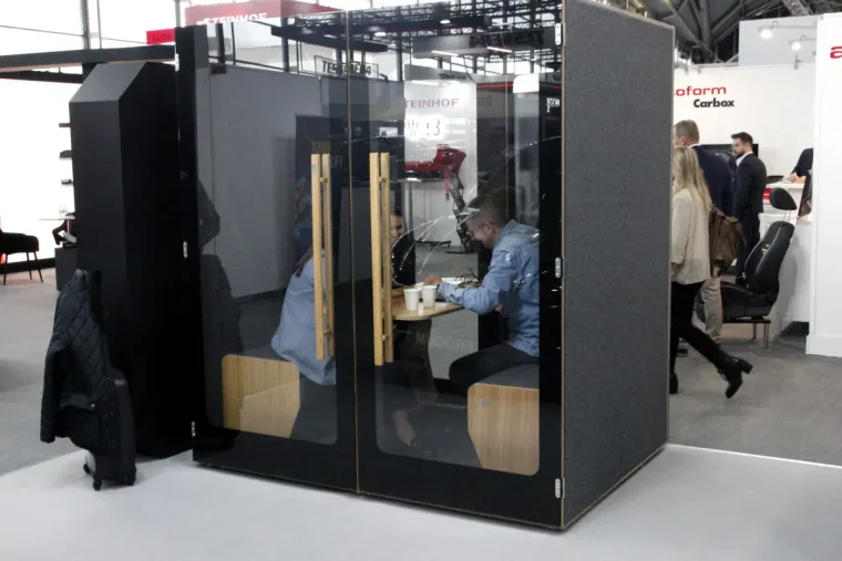 HIDE H4 acoustic booth at the FroGum stand during the Automechanika trade fair, two men at the table