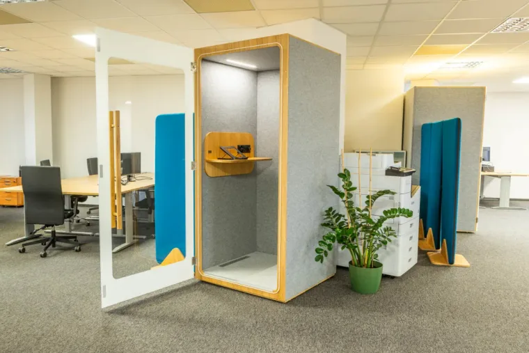 Open light-grey HIDE H1 acoustic booth with a blue door panel in an open-plan office