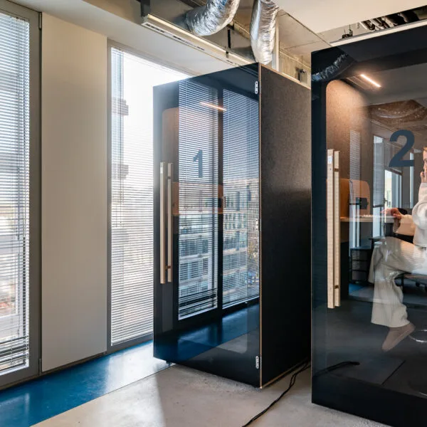 Square thumbnail of two black HIDE H1 acoustic booths by a window with blinds
