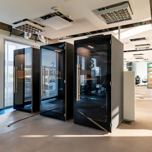Three black HIDE H1 acoustic booths numbered 1, 2 and 3 in an open-plan office
