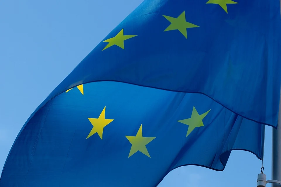 Close-up of a waving European Union flag with yellow stars against the sky