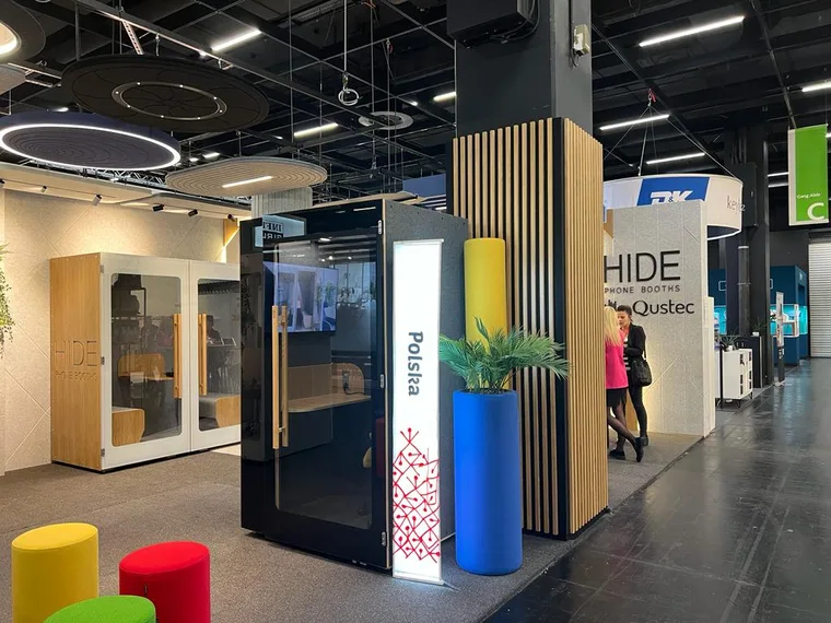 A dark booth and a white HIDE H1+ booth side by side at HIDE's own trade fair stand