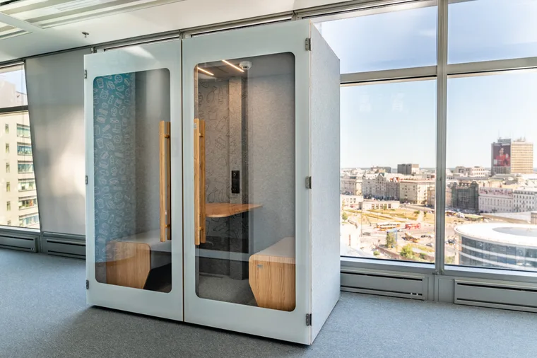 Light HIDE H2 acoustic booth by a panoramic window, with a food-themed wallpaper inside